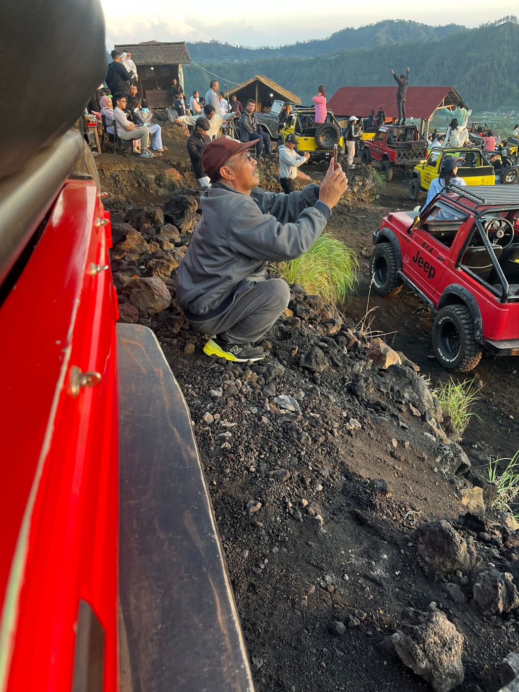 An older man taking a photo from a deep squat in Bali